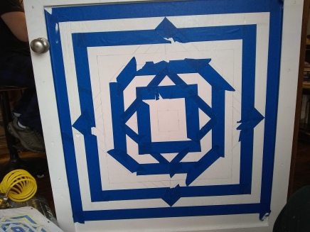Taping off the first round of colored lines on the "Over Under Square" Pattern